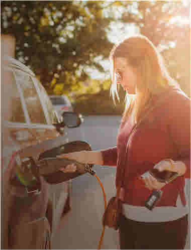 Woman connecting electric car
